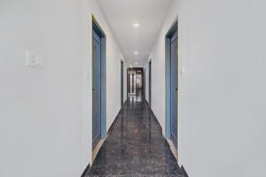 un corridoio vuoto con porte blu in un corridoio bianco di Super Capital O Qualia Gachibowli a Hyderabad