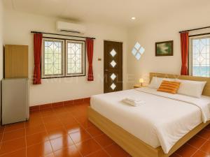 a bedroom with a large white bed and windows at Samui Smile Stay in Mae Nam
