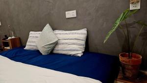 a bed with two pillows on a blue sheet at La Sen-Thu An-Có cửa sổ nhìn ra ban công in Thôn An Hòa