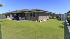 a house with a large lawn in front of it at The Eel Place Retreat in Bongaree