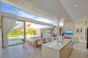 an open kitchen and living room with a view of a pool at Asherah Villa By Asherah Team in Ban Phru Champa