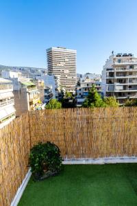 a wooden fence with a green yard in a city at Ρετιρέ με θέα in Athens