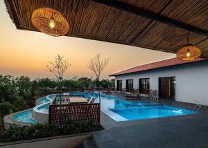 a house with a swimming pool and a patio at Manduva house in Zahirābād