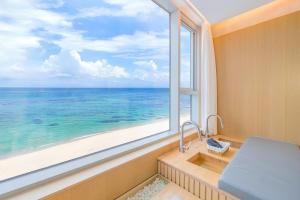a bathroom with a window with a view of the ocean at The Youngjin Pool Villa Pension in Yŏngjin 2-ri