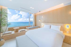 a bedroom with a large white bed and a large window at The Youngjin Pool Villa Pension in Yŏngjin 2-ri +12 photos