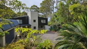 una casa en medio de un bosque en George Bass Drive A Well Kept Secret managed by Batemans Bay Accom, en Surf Beach