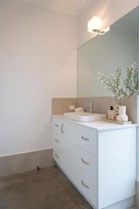 Un baño blanco con lavabo y espejo. en Solara Escape - A laid-back and luxurious beach bungalow, en Margaret River Town 35 fotos más