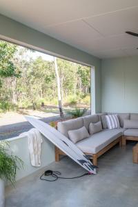 sala de estar con sofá y tabla de surf en la pared en Solara Escape - A laid-back and luxurious beach bungalow, en Margaret River Town
