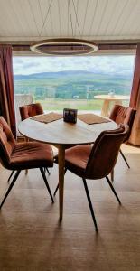 a table and chairs in a room with a large window at Mountain Cabin With Panoramic Views In Brakastølen in Ron