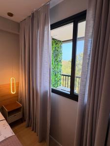 a bedroom with a window with a view at Varanda com Vista Mar - Cristo, Bondinho e Museu! in Niterói +28 photos