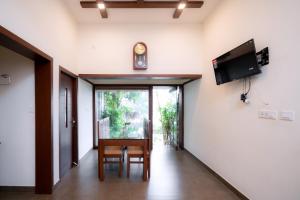 a dining room with a table and a clock on the wall at Thiraa Inn Nilambur By Hotelbuz in Nilambūr