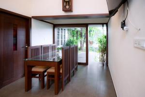 a hallway with a table and chairs in a house at Thiraa Inn Nilambur By Hotelbuz in Nilambūr