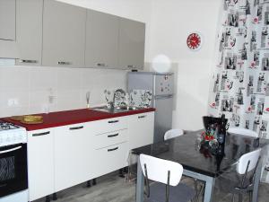a kitchen with white cabinets and a table with chairs at APPARTAMENTO Exclusive in Marsala