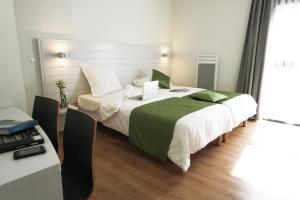 sypialnia z dużym łóżkiem i biurkiem w obiekcie Arc en Ciel Oléron w mieście Saint-Trojan-les-Bains