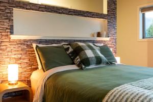 a bedroom with a bed with a brick wall at Relaxing Rural Retreat - Stargaze or Soak Up the Sun in Luggate +9 photos