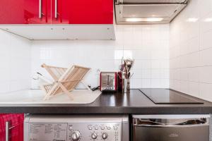 a kitchen with red cabinets and a counter top at Studio ToulouseCityStay Basso Cambo in Toulouse