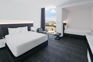 a hotel room with two beds and a window at Hotel ORA Incheon in Incheon