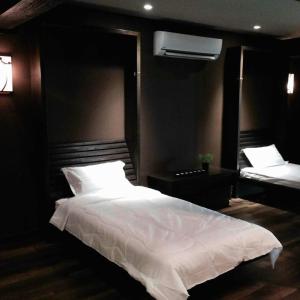 a bedroom with a large white bed and a mirror at Miracle Suite in Ipoh