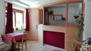 a living room with a fireplace and a table at Pensione Valbona in Corvara in Badia