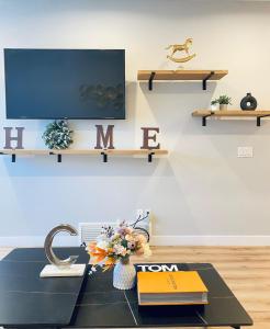 a living room with a table with books and a tv at The Downtown Oasis - A Spacious Family Friendly 3 Bedroom House Close to Everything in Edmonton