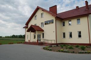 un gran edificio blanco con un cartel. en Przystanek Czapla, en Czaplinek