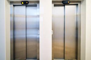 two metal elevator doors in a building at Apartment Capital Town-free parking in Zagreb