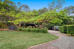 a house with a garden and a walkway at Anembo Country Cottages in Eatons Hill