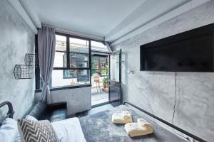 a room with a tv and a bed and a couch at Goodnight hotel in the ancient Hutong in Beijing