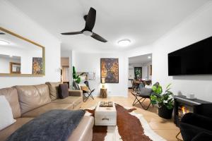 a living room with a couch and a flat screen tv at Anembo Country Cottages in Eatons Hill