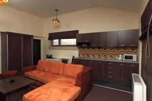a living room with a couch and a kitchen at Family Hotel - Restaurant Ring in Montana