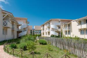 a row of apartment buildings with a fence at Résidence L'Océane, Andernos in Andernos-les-Bains