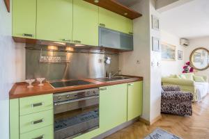 a kitchen with green cabinets and a sink at Apartment Free Spirit in Split