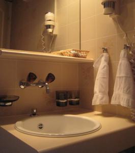 グリンデルワルトにあるガストホフ アルテ ポストのバスルーム(シンク、鏡、タオル付)
