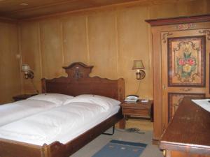 グリンデルワルトにあるガストホフ アルテ ポストのベッドルーム1室(ベッド1台、デスク、電話付)