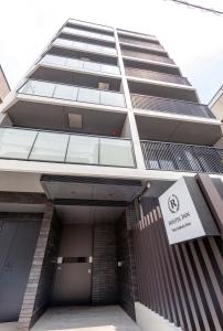 a tall building with a sign in front of it at Hostel Inn Tokyo Asakusa Annex in Tokyo