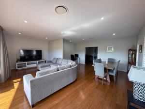 a living room with a couch and a table at 500m to Werri Beach - The Palms in Gerringong