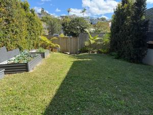 a yard with a fence and a garden at 500m to Werri Beach - The Palms in Gerringong