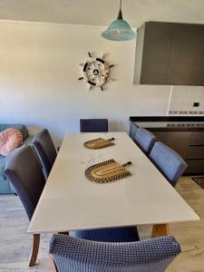 a white table with blue chairs and a kitchen at Algarrobo descanso junto al mar in Mirasol