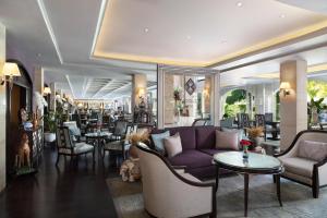 バンコクにあるThe Sukosol Hotelの紫色のソファと椅子とテーブルのあるロビー