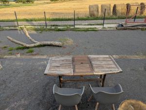 a wooden table and two chairs in a parking lot at Un rêve qui devient réalité in Zilling