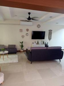 a living room with a couch and a flat screen tv at Ujana Kingfisher double storey 3 Bedroom - Farah Biz Homestay in Kota Kinabalu