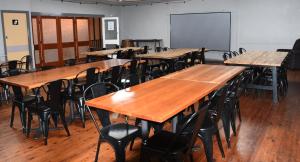 una clase con mesas y sillas de madera y una pizarra en Leichhardt Hotel, en Taroom