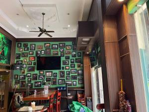 a dining room with a table and a wall of pictures at The Dubliner Inn in Phnom Penh