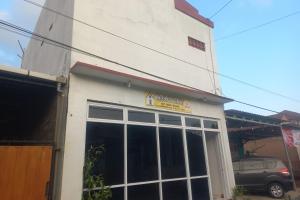 a white building with a large window in front of it at OYO 94771 White House Arafah Syariah in Purwokerto
