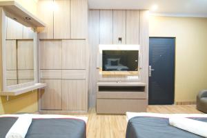 a room with two beds and a flat screen tv at Collection O 94762 Starlight in Pekanbaru