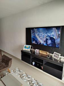 a living room with a large flat screen tv at Colares House Pedra de Guaratiba - 2 quartos - style and comfort in Pedra de Guaratiba