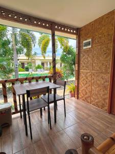 a patio with a wooden table and a bench at Imagine Bohol in Panglao