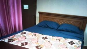 a bed with a blue comforter and blue pillows at 7th Heaven Kannur in Kannur