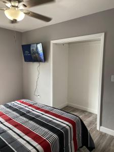 a bedroom with a bed and a tv on the wall at The blue Homestay near Miami Airport in Miami