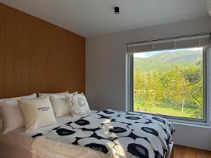 a bedroom with a bed with a large window at Villa At On Organic Farm in Ban Wak